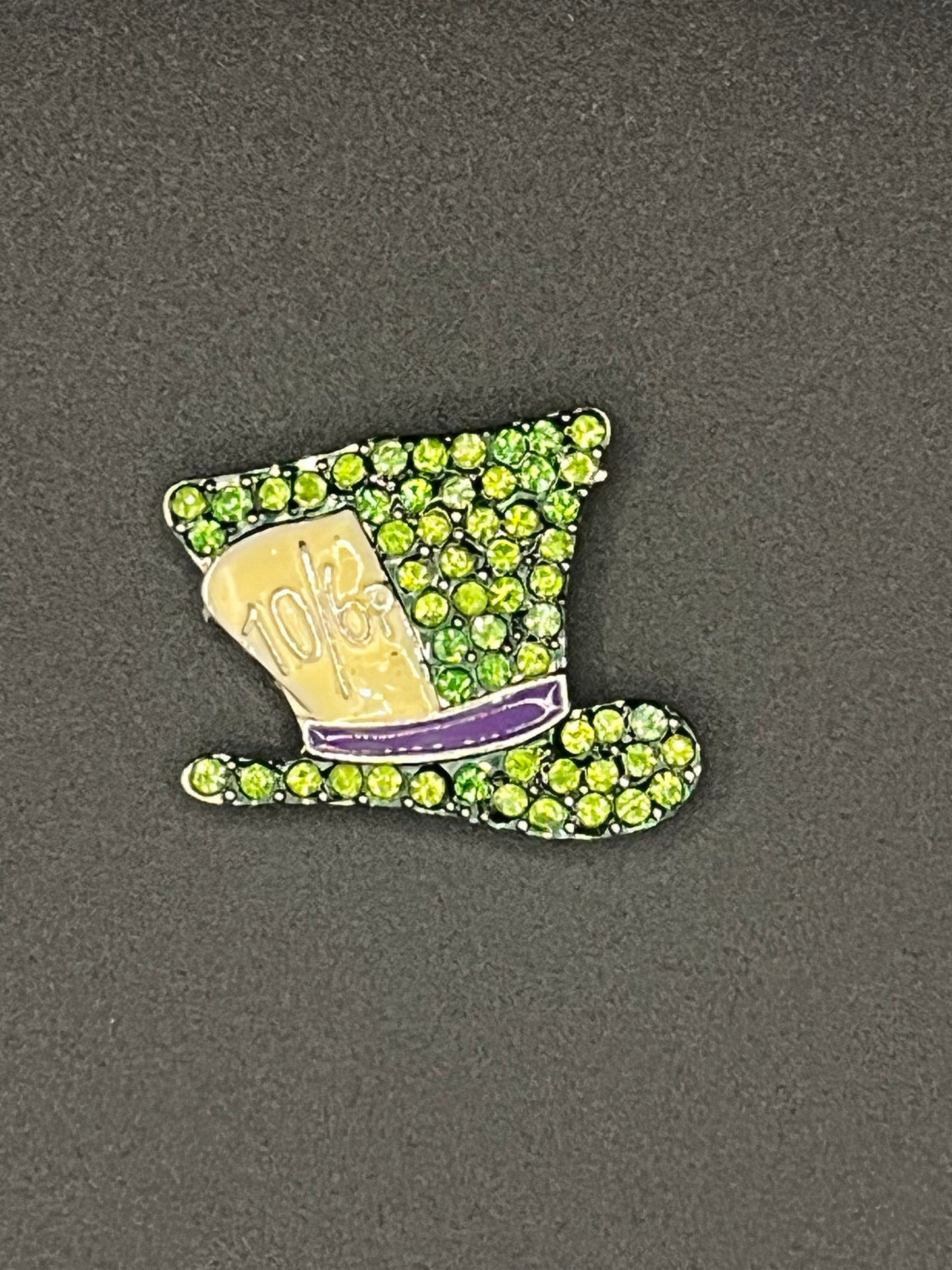 Needle minder with green gemstones on a gray background