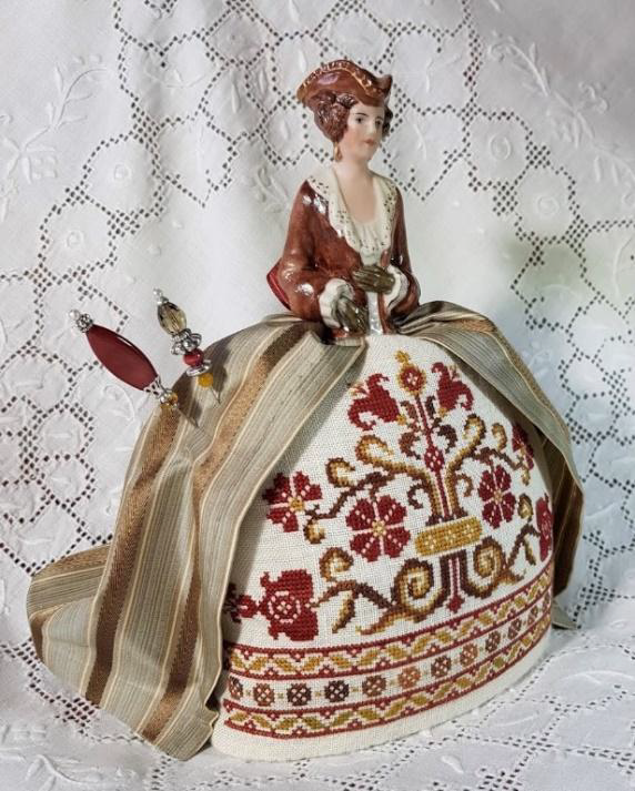 Embroidered design of a woman in a dress with floral patterns on a lace background