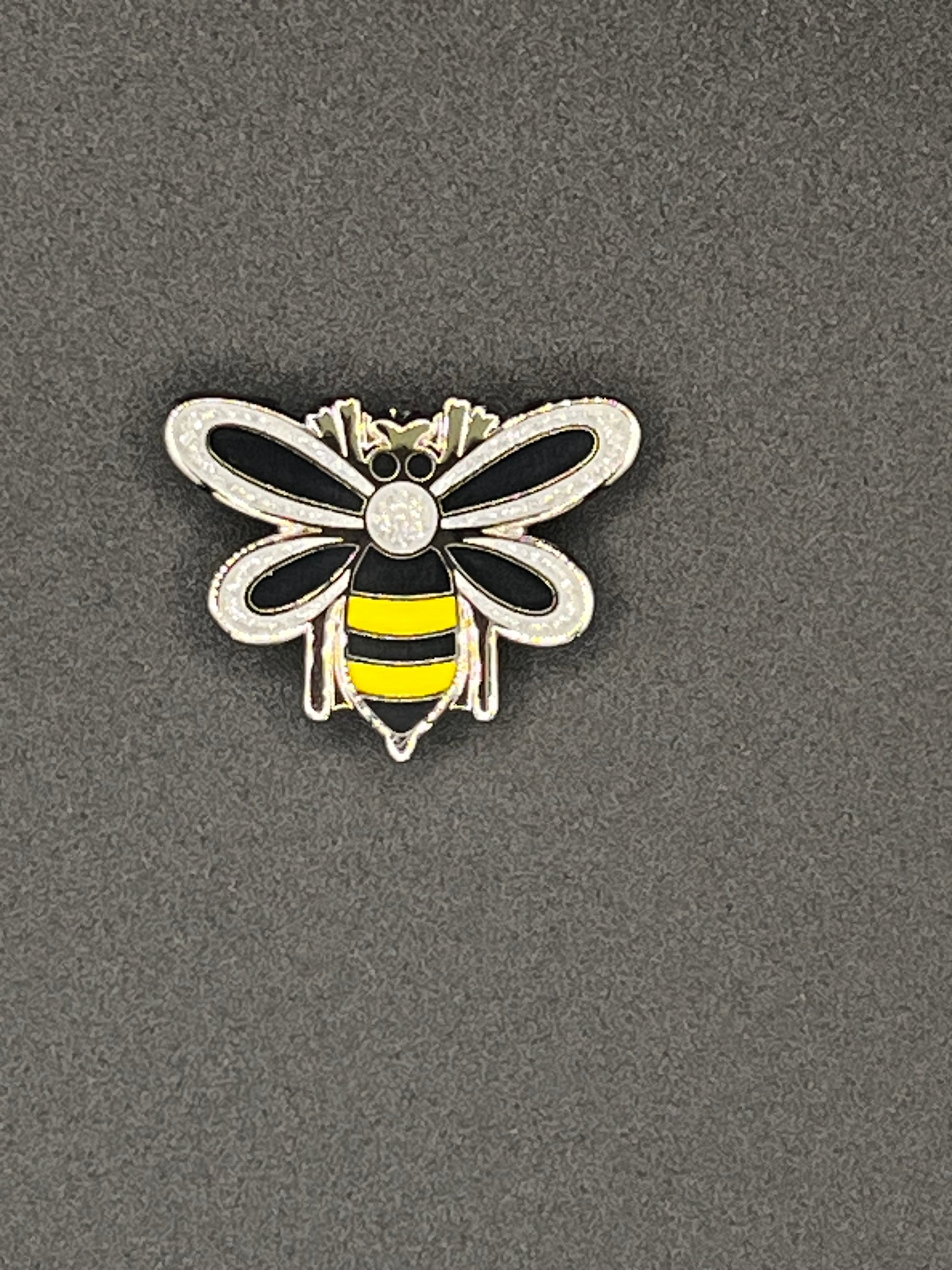 Bee-shaped needle minder on a gray background