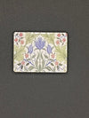 Small rectangular tile needle minder with floral design on a dark gray background