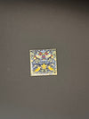 Small decorative tile needle minder with floral pattern on a dark gray background