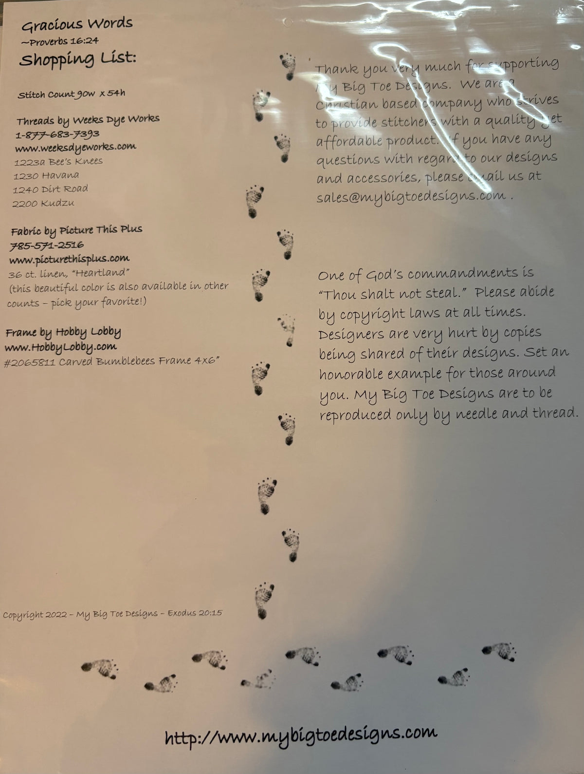 A close-up of a printed sewing patterns and text. The text includes 'Gracious Words' and 'Shopping List:' followed by contact details for My Big Tie Designs, along with small printed illustrations of hands holding sewing machines and sewing needles.