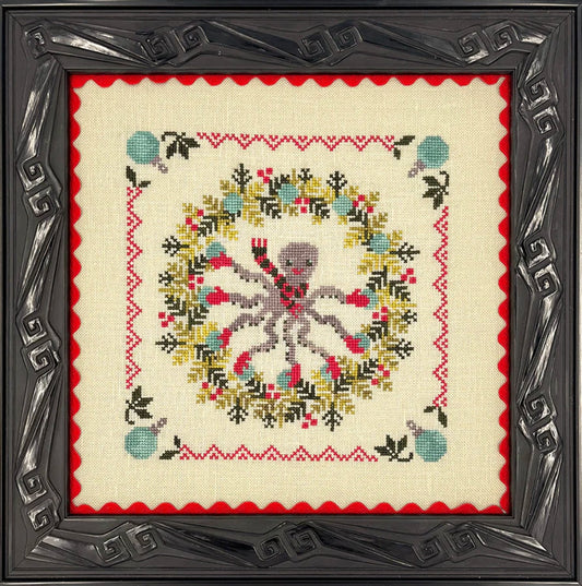 Decorative cross-stitched design with a skull and floral wreath in a decorative frame.