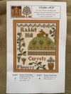 Cross-stitch pattern with a rabbit and carrots design on a white background