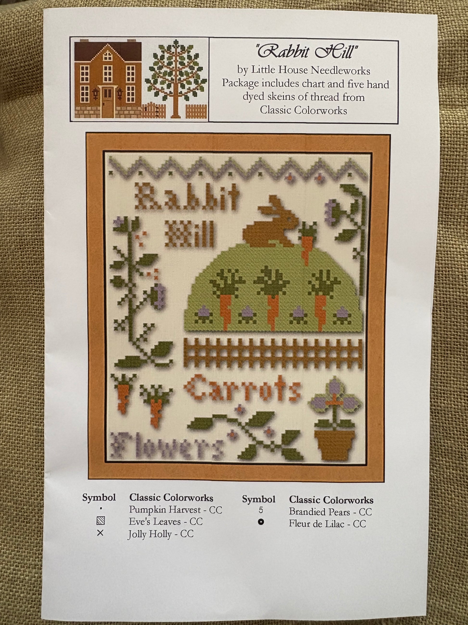 Cross-stitch pattern with a rabbit and carrots design on a white background