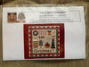 Cross-stitch kit packaging with design and branding details on a textured surface