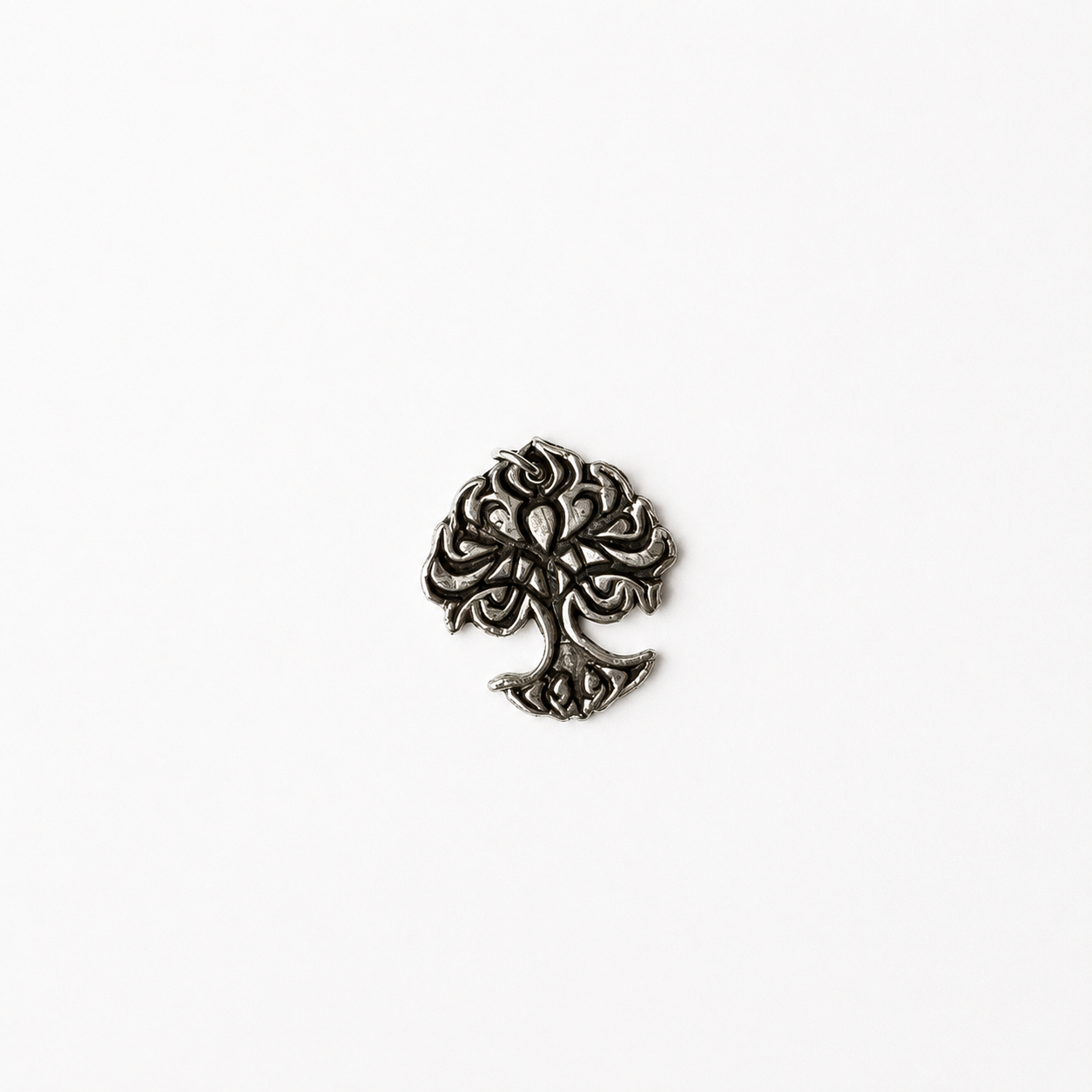 Decorative silver tree of life pendant on a white background