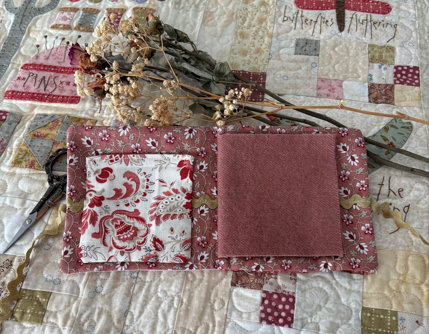 Fabric sample with floral patterns on a patchwork background