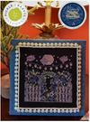 Cross-stitched piece with a night scene design on a blue fabric background, featuring Pickle Barrel Designs branding.