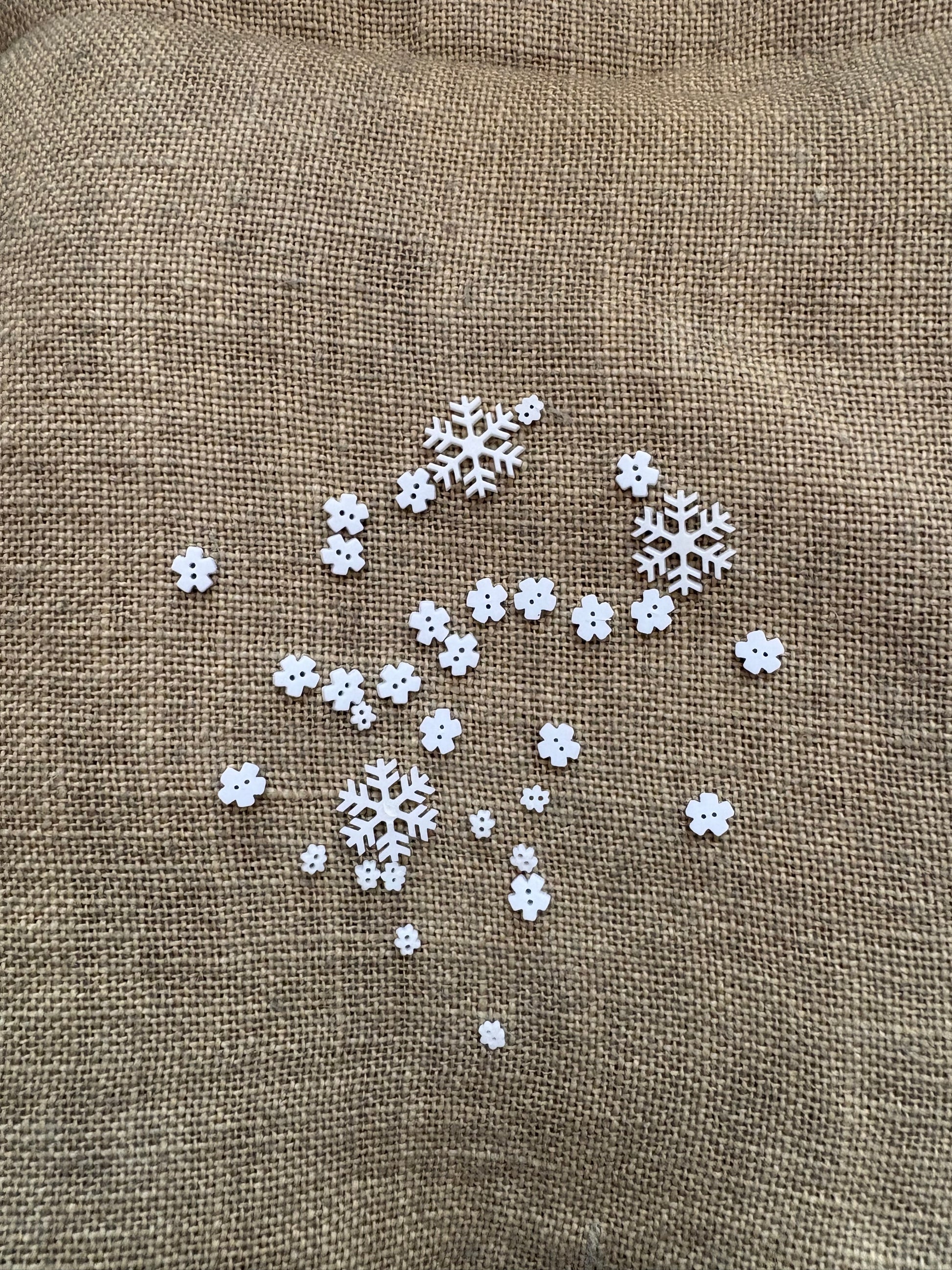 White snowflake decorations on a brown fabric background