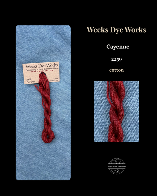 Red yarn skein with Weeks Dye Works label on a blue background