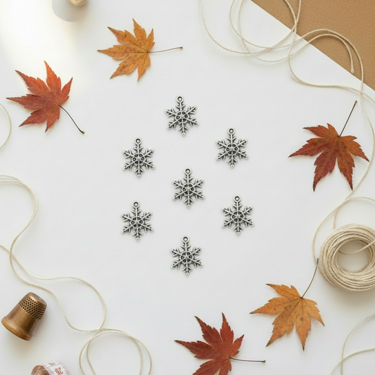 Antique silver snowflake charms on autumn background